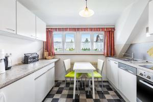 a kitchen with white cabinets and a table and chairs at Gita in Öhningen +15 photos