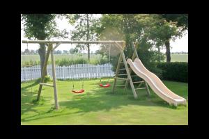 a playground with two swings and a slide at Ferienhaus Nanny Und Helene in Uphusum