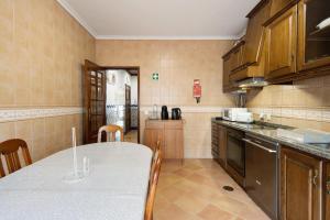 a kitchen with a table and a counter top at Barra Sol - Lighthouse On The Beach in Gafanha da Nazaré