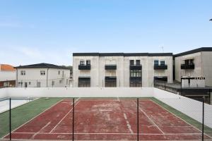 a tennis court in front of a building at Barra Sol - Lighthouse On The Beach in Gafanha da Nazaré