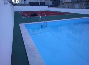 a swimming pool with a blue light in a building at Barra Sol - Lighthouse On The Beach in Gafanha da Nazaré