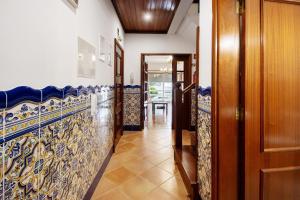 a hallway with blue and white tiles at Barra Sol - Lighthouse On The Beach in Gafanha da Nazaré +23 photos