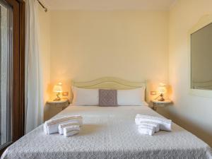 a bedroom with a bed with two towels on it at Maison Pinella in Villasimius