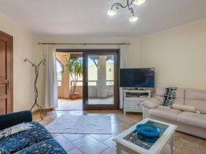 a living room with a couch and a tv at Maison Pinella in Villasimius