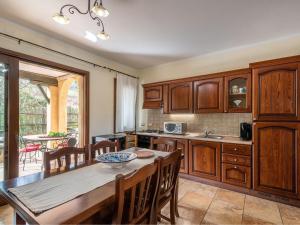 a kitchen with wooden cabinets and a table with chairs at Maison Pinella in Villasimius