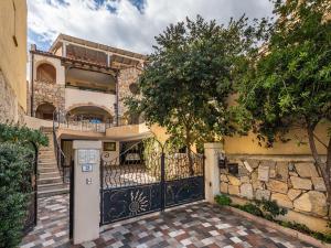 a house with a gate and a tree in front of it at Maison Pinella in Villasimius