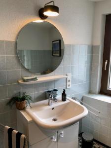 a bathroom with a sink and a mirror at das rote Ferienhaus Terlinden in Lieser +37 photos