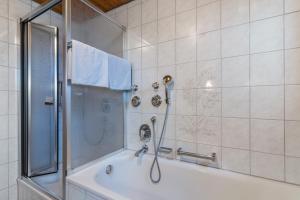 a bathroom with a shower and a bath tub at Fewo Schwarzwald - Haus Sommerberg in Baiersbronn +14 photos