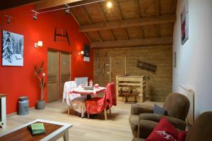 a living room with red walls and a table at La Chambre De Jaxel in Saint-Martin-en-Vercors
