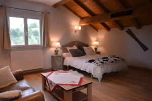 a bedroom with a bed and a couch and a window at La Chambre De Jaxel in Saint-Martin-en-Vercors +21 photos