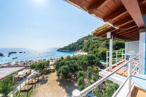 a view of the beach from the balcony of a resort at Alex bar apartments in Parga
