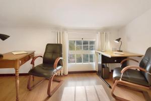 a room with a desk and two chairs and a table at Casa Amarela in Caniço