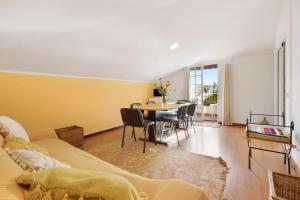 a living room with a table and a yellow wall at Casa Amarela in Caniço