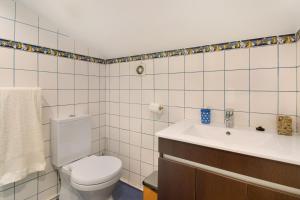 a bathroom with a toilet and a sink at Casa Amarela in Caniço +17 photos