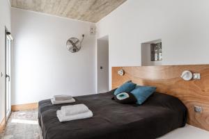 a bedroom with a large bed with black sheets and blue pillows at A The Country House in Tinos