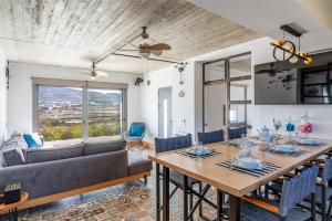 a dining room with a table and a couch at A The Country House in Tinos