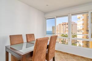 a dining room with a table and chairs and a window at Apto Urb Centro Internacional A117 in Torrox