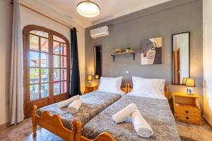 a bedroom with two beds and a window at Nana's House Holidays Greece in Dragotiná