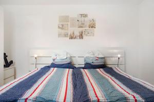 a bed with a red white and blue striped blanket at Achterkajüte in Bodman-Ludwigshafen