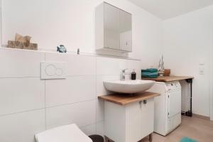 a white bathroom with a sink and a counter at Achterkajüte in Bodman-Ludwigshafen +13 photos