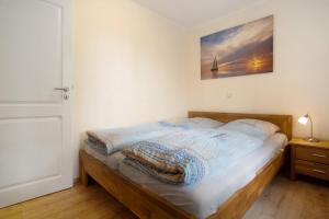 a bedroom with a bed with a picture on the wall at Haffmöwe Ferienhaus 96 in Mönkebude