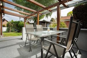 a table and chairs on a patio with a pergola at Haffmöwe Ferienhaus 96 in Mönkebude