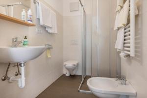 a white bathroom with a sink and a toilet at App Sonne Nr 21 in Lutago +9 photos