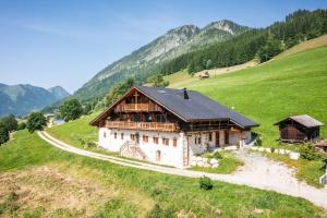 a house on a hill with mountains in the background at Le Perray Alpine Lodge in Abondance