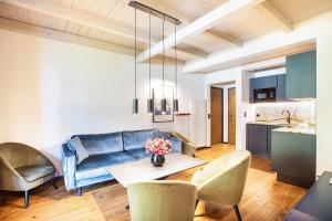 a living room with a couch and a table and chairs at Kraidlhof Designapartment Veronika in Cortaccia