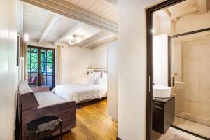 a bedroom with a bed and a bathroom at Kraidlhof Designapartment Veronika in Cortaccia