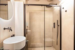a bathroom with a glass shower and a white sink at Kraidlhof Designapartment Veronika in Cortaccia +28 photos