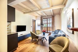 a living room with a couch and chairs and a table at Kraidlhof Designapartment Veronika in Cortaccia