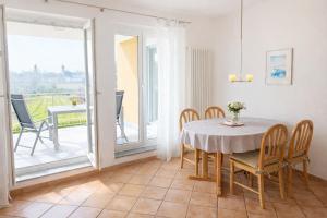 a dining room with a table and chairs and a balcony at Haus Sonnenseite Wohnung Säntis in Wasserburg