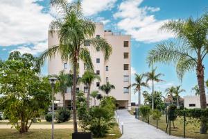 a building with palm trees in front of it at Playamarinsa in Torre del Mar