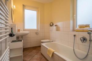 a bathroom with a tub and a sink at Haus Sonnenseite Wohnung Säntis in Wasserburg +26 photos