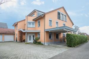 a large orange house with a driveway at Haus Sonnenseite Wohnung Säntis in Wasserburg