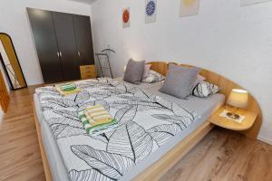 a bedroom with a large bed with a black and white blanket at Ferienwohnung Zapf in Forbach