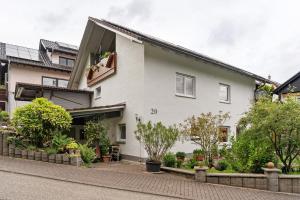 a white house with plants on a street at Ferienwohnung Zapf in Forbach