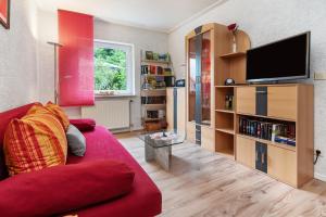 a living room with a red couch and a tv at Ferienwohnung Zapf in Forbach