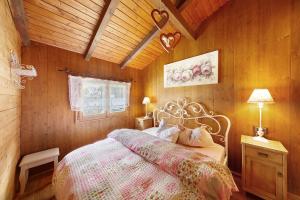 a bedroom with a bed in a room with wooden walls at Orserose Chalet 3 I Ciodi in Forno di Zoldo