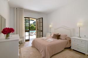 a white bedroom with a large bed and a patio at V4 Galeão Vilamoura in Vilamoura +26 photos