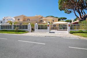 a white fence in front of a house at V4 Galeão Vilamoura in Vilamoura