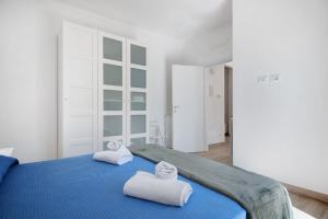 a bedroom with a blue bed with towels on it at Moneglia Mare in Moneglia