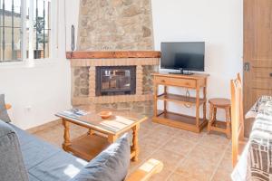 a living room with a couch and a fireplace at Bungalows La Aceitera - Apartamento 2 in Zahora