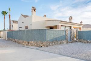 a house with a stone fence in front of it at Bungalows La Aceitera - Apartamento 2 in Zahora