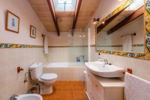 a bathroom with a toilet and a sink and a tub at Finca Ses Coves in Petra +27 photos
