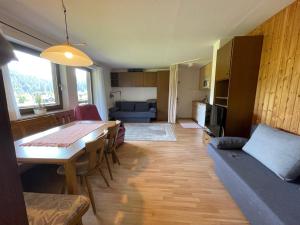 a living room with a table and a dining room at Fewo 2 am Auweg in Hirschegg
