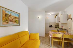 a living room with a yellow couch and a table at Villa sole e mare in Cipressa