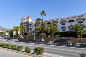 a building with palm trees on the side of a road at Verano Azul in Nerja