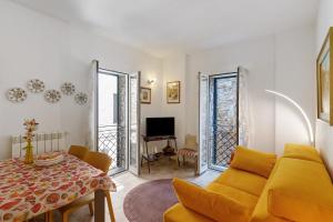 a living room with a yellow couch and a table at Villa sole e mare in Cipressa